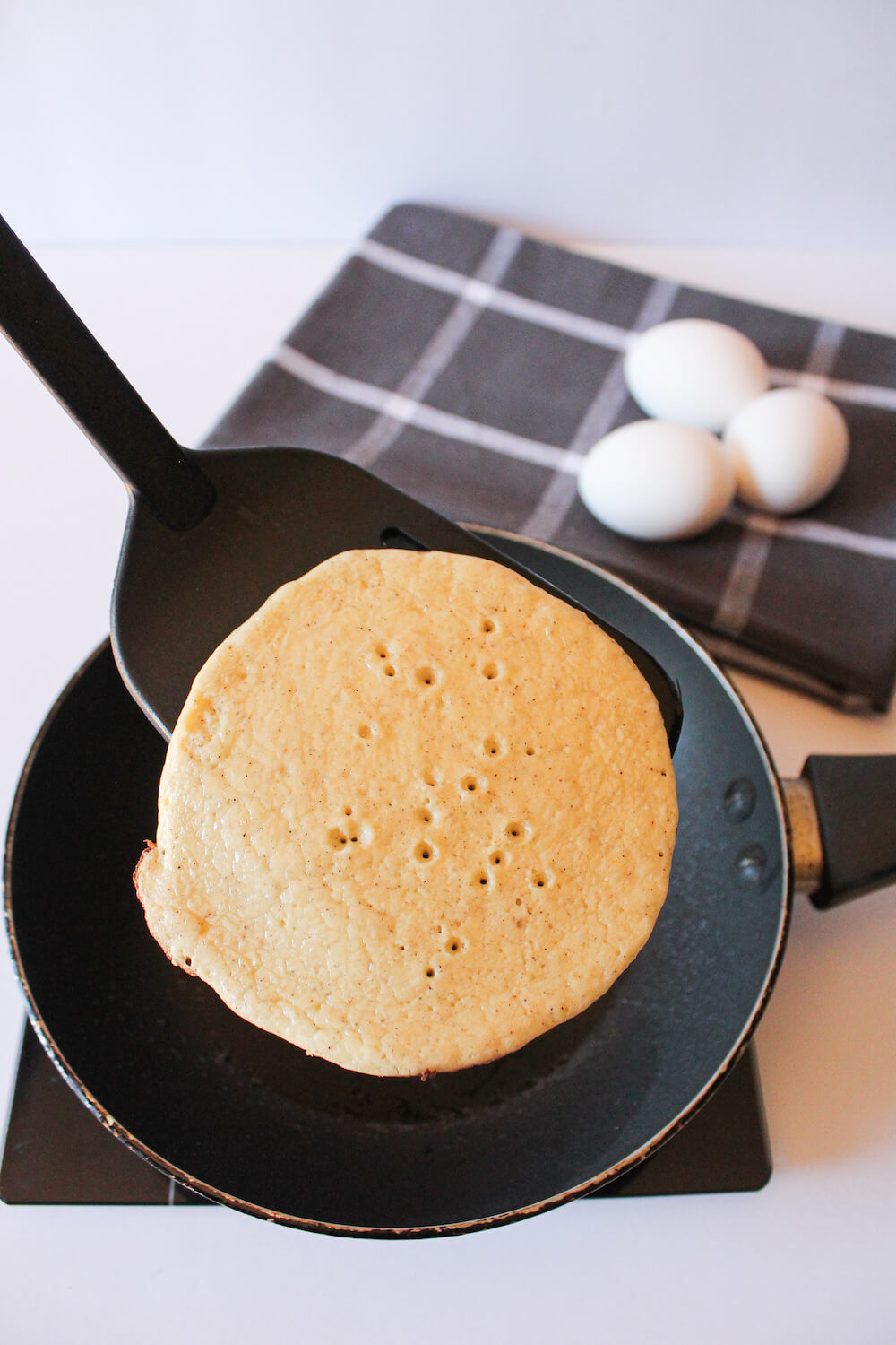 Flipping a keto almond flour pancake in the pan