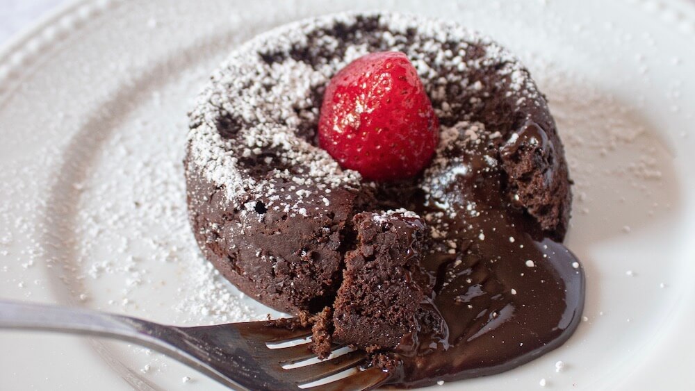 The best keto lava cake with fork taking a bite.